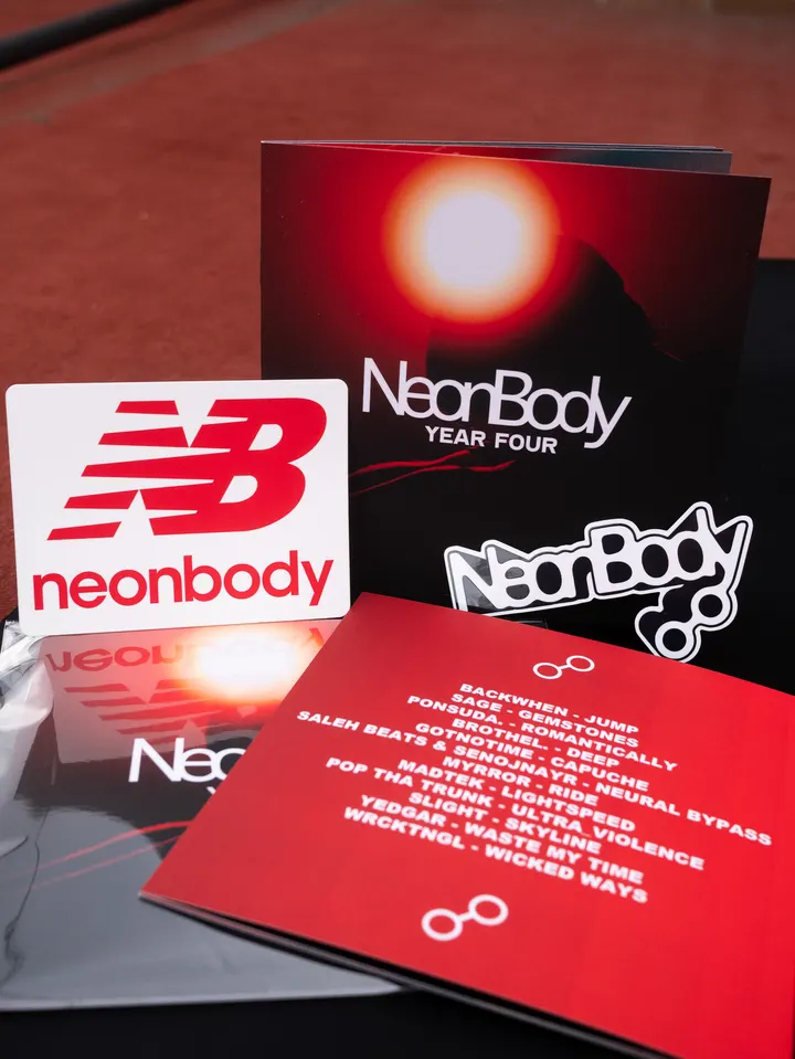The NeonBody Year Four package: the art book with a red sun on its cover, its red tracklist page, and the two NeonBody sticker designs.